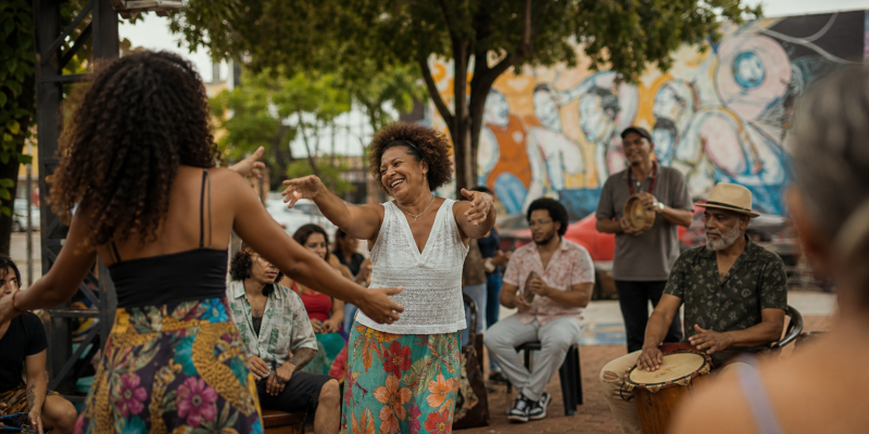 Atividade cultural comunitária em espaço público de Três Lagoas, com artistas e moradores reunidos