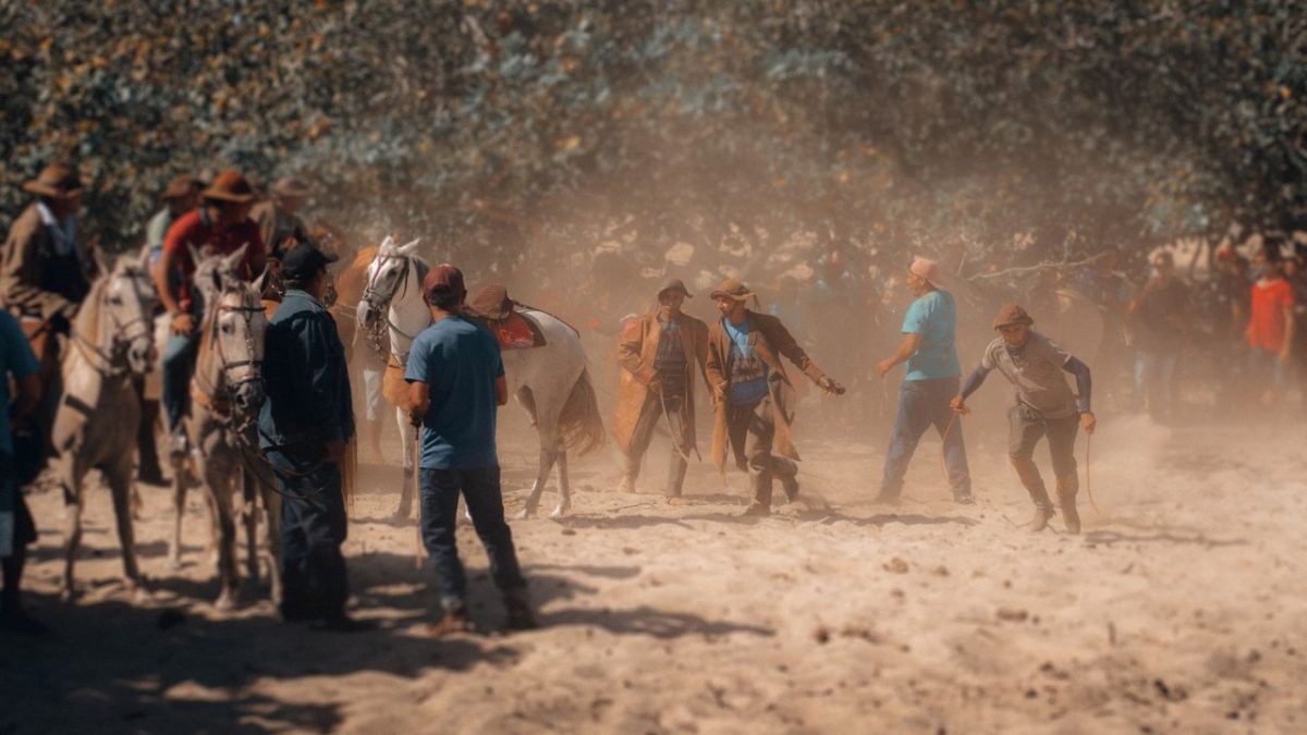 Participantes montados a cavalo durante um evento tradicional em área rural brasileira.