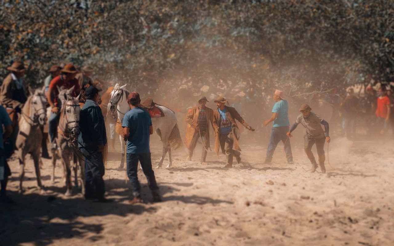 Participantes montados a cavalo durante um evento tradicional em área rural brasileira.