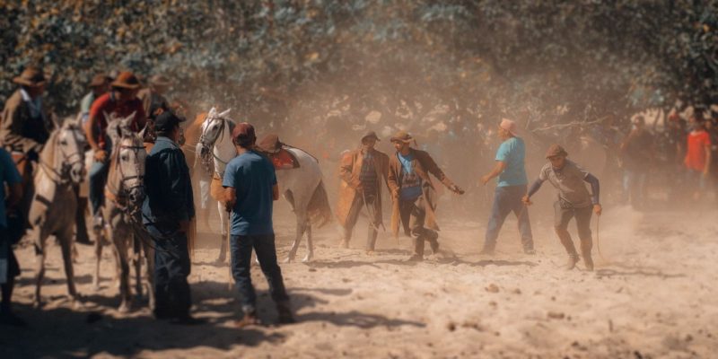 Participantes montados a cavalo durante um evento tradicional em área rural brasileira.